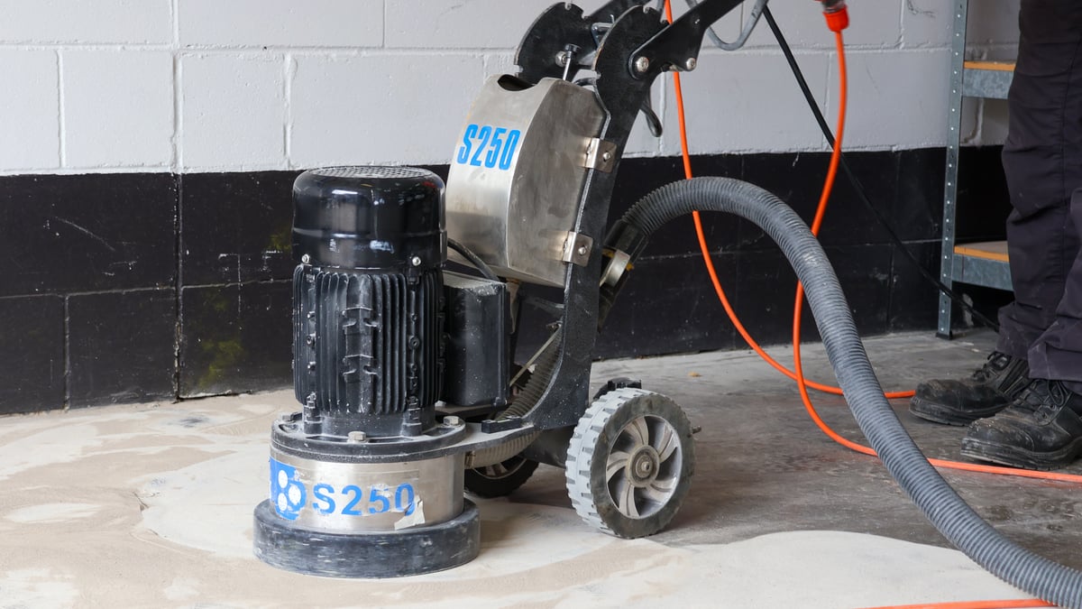 Diamond grinding machine preparing concrete floor surface before self-leveling primer application