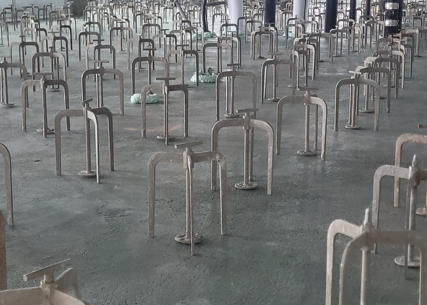 Close view of adjustable leveling pedestals set across a bare concrete slab
