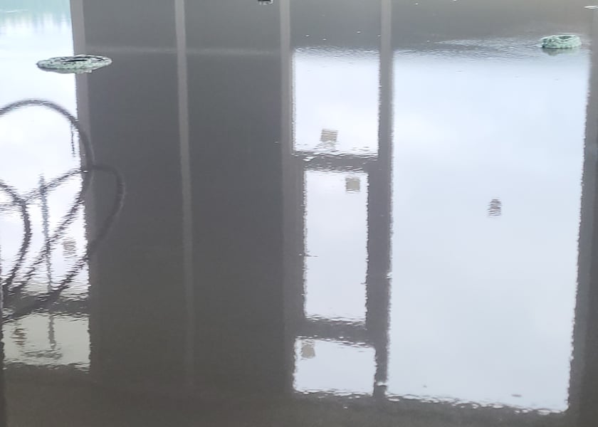 Reflection of window mullions and pipe risers in a freshly poured self-leveling floor