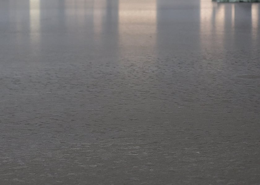 Close up of a wet self-leveling compound surface showing its texture and reflections