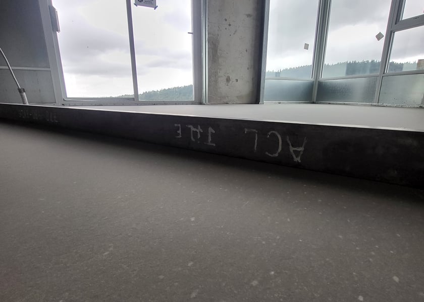 Straightedge tool laid along a window sill with hills visible through the windows